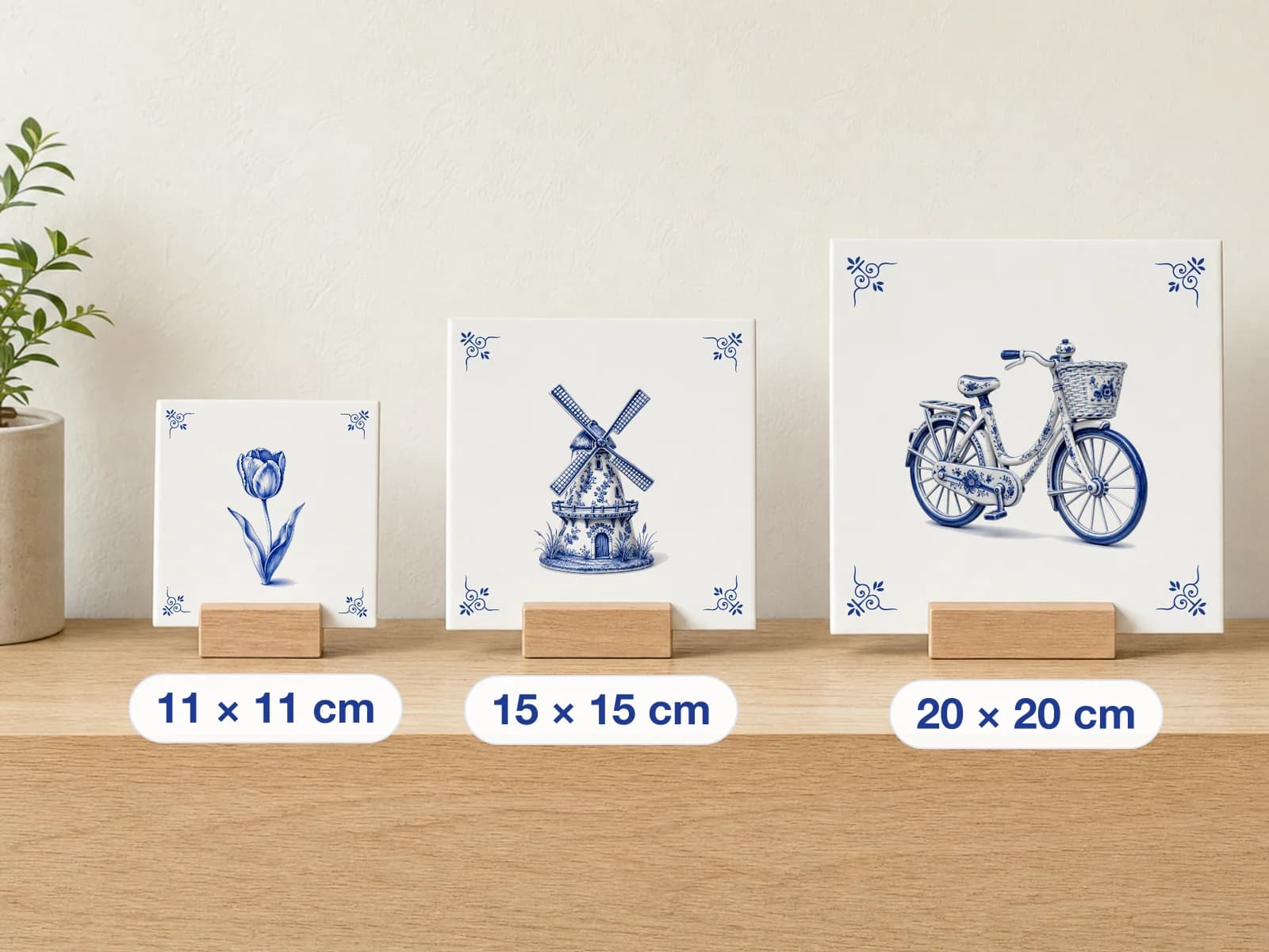 Three Delft Blue tiles side by side on a shelf: 11, 15 and 20 cm