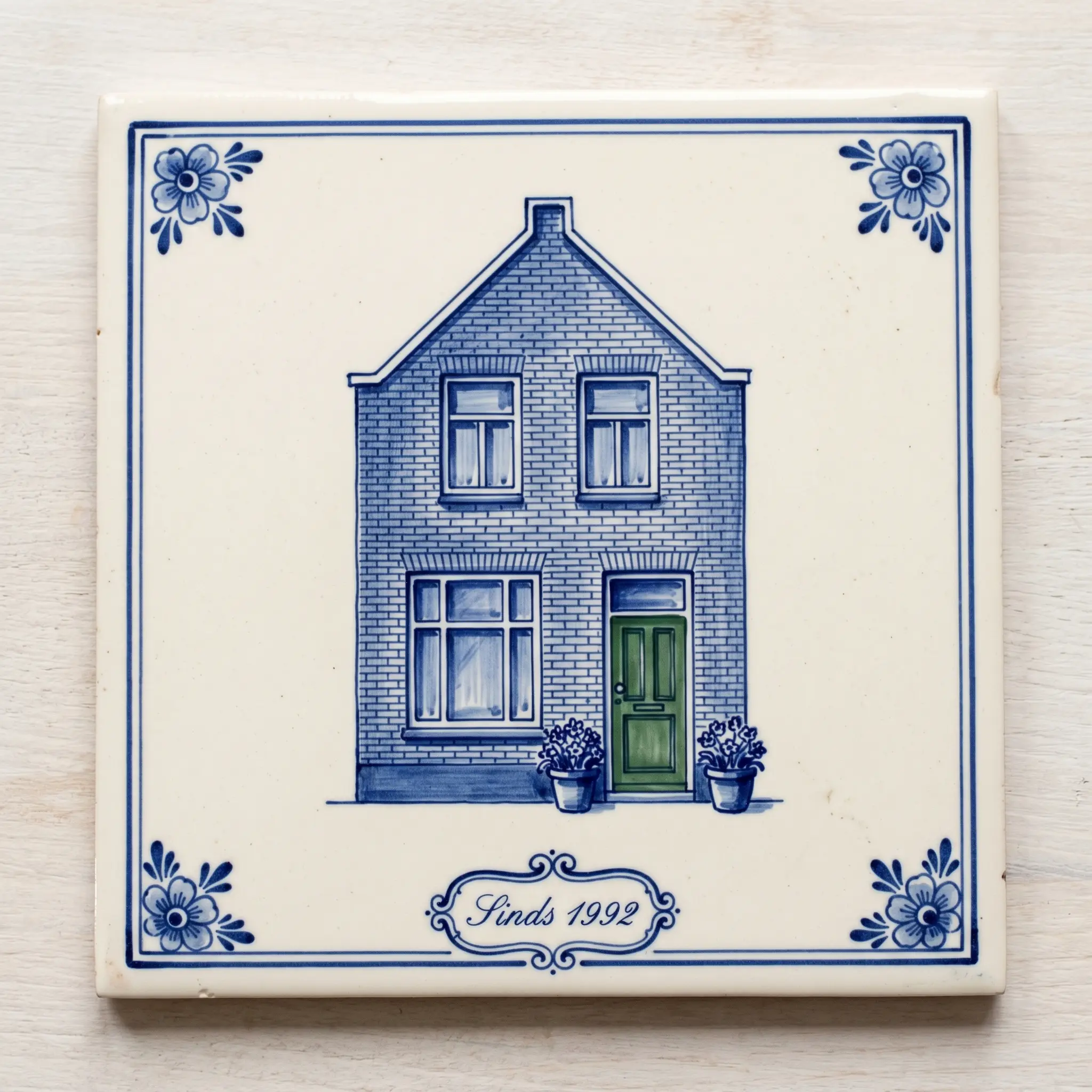The same Dutch home rendered as a Delft Blue tile in cobalt brushstrokes